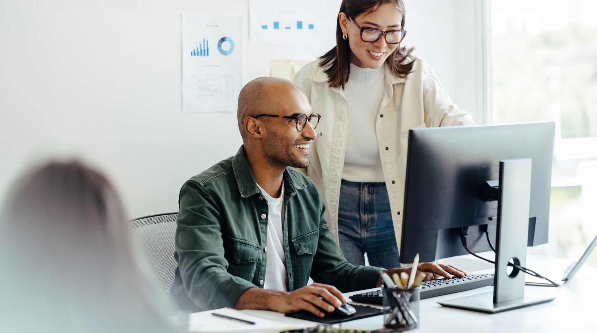 Programiści analizujący dane w biurze, symbolizujący partnerstwo GlobalLogic, Hitachi i Google Cloud, które ma na celu przyspieszenie innowacji i zwiększenie produktywności przedsiębiorstw poprzez rozwiązania generatywnej AI w zakresie modernizacji oprogramowania i środowisk chmury hybrydowej.