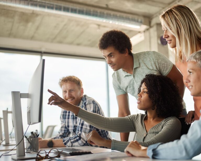 A diverse group of software engineers working collaboratively in a brightly lit office on the design and engineering of an intelligent next-generation AI platform.