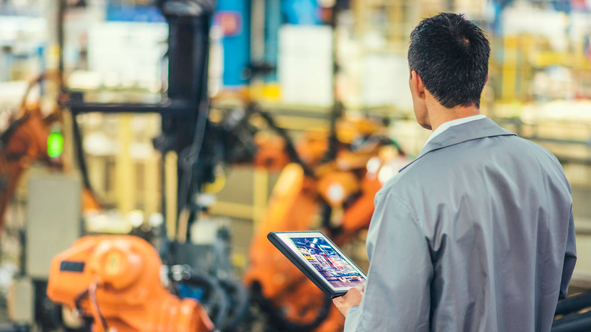 Engineer working in a smart factory environment, leveraging IT/OT integration, IoT connectivity, and real-time data analytics to monitor and optimize industrial operations for Industry 4.0 transformation.