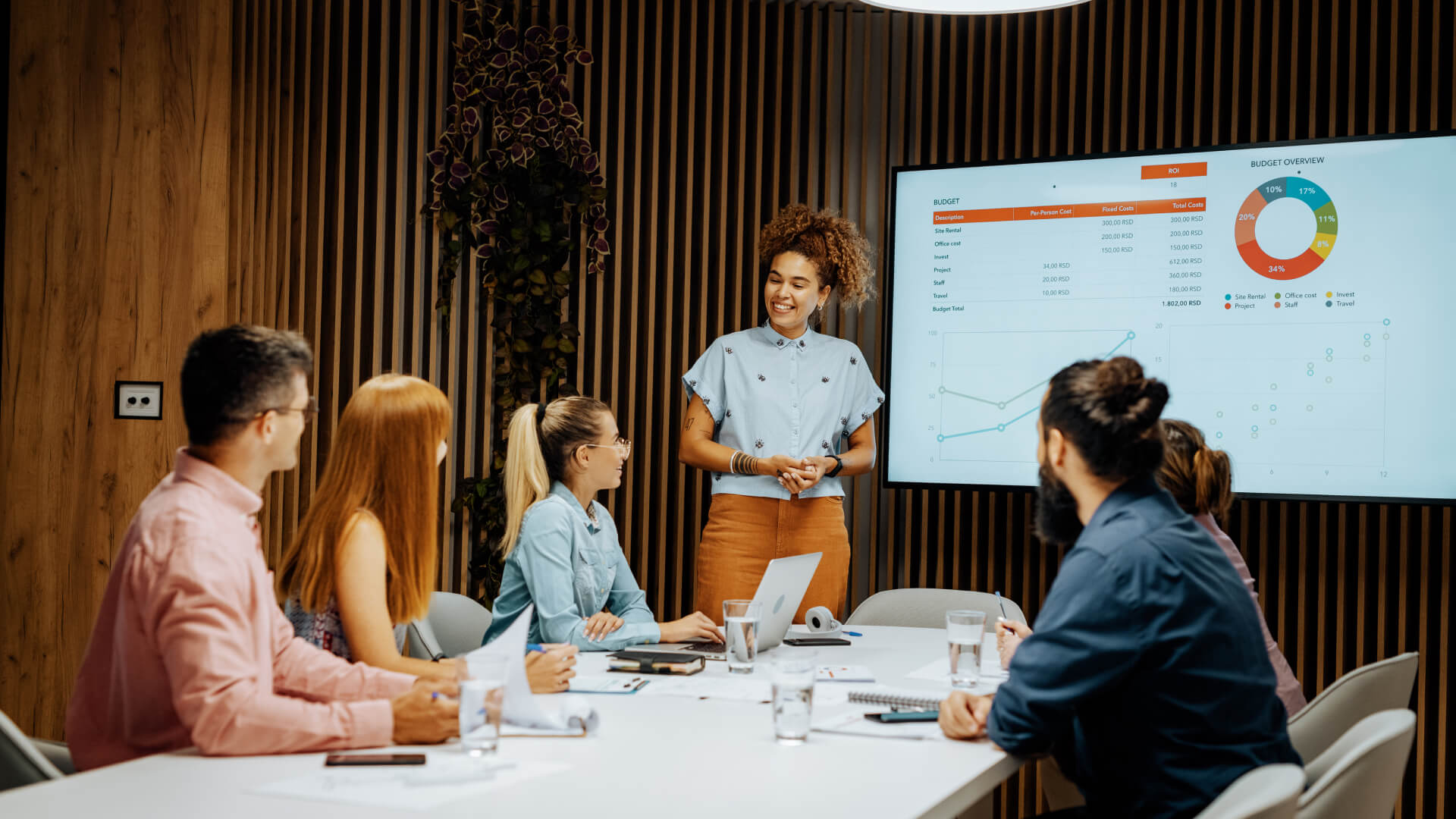 Digital engineering team collaborating in a modern office, with an African American businesswoman leading a presentation on digital transformation strategy and advisory services.