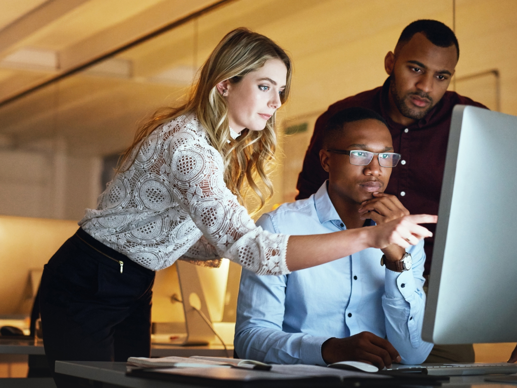 Three engineers collaborating in a modern workspace, strategizing and implementing digital transformation solutions with a focus on governance, execution, and business impact.